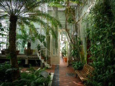 Lush Greenhouse Retreat with Spiral Staircase & Brick Flooring