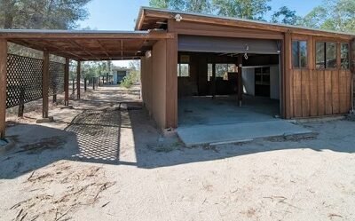 Rustic garage with open sides and desert backdrop